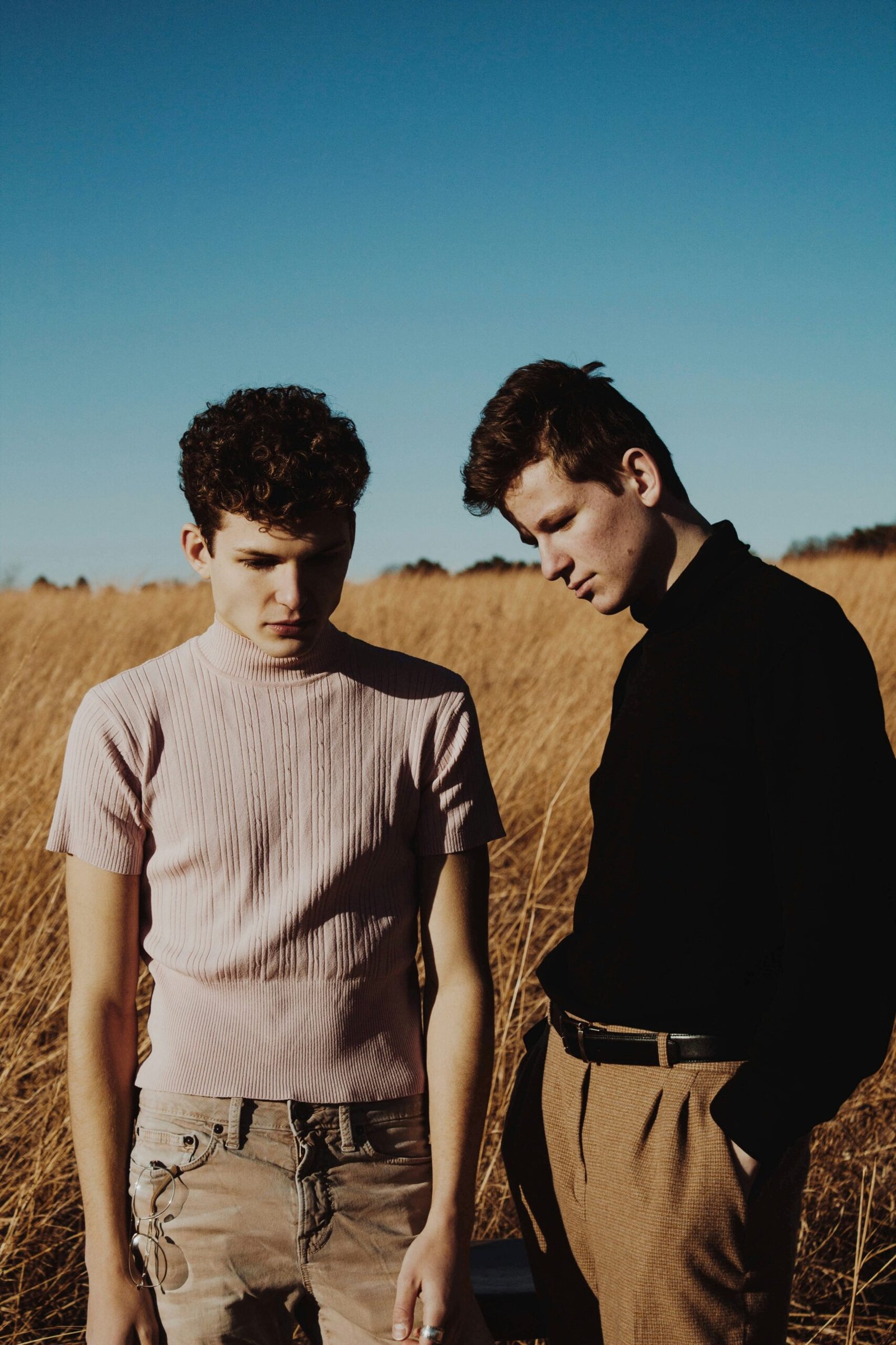 two men standing on grass field